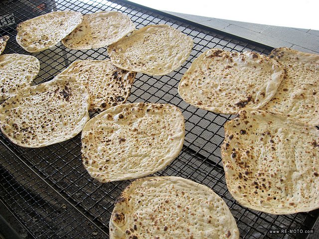 Delicious Persian bread, baked in ovens with tiny hot stones. Some stones stick to the bread and the clients pick them off on this mesh.